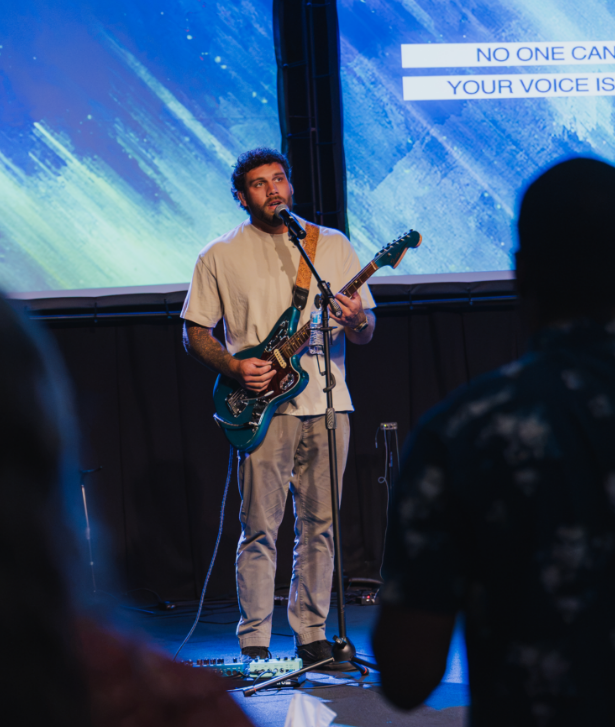 Guitarist leading worship on stage