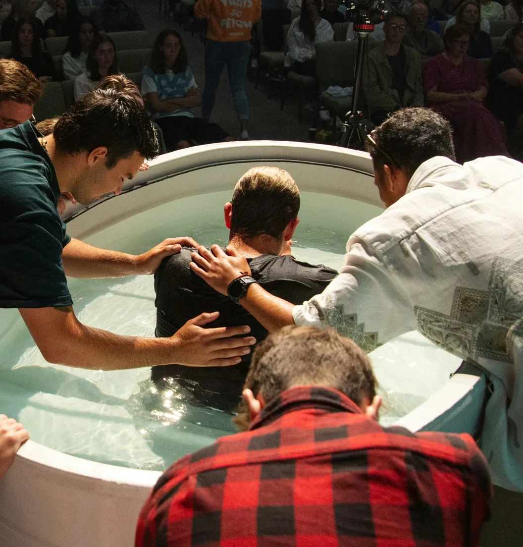 Pastors baptizing a man in the baptismal tank