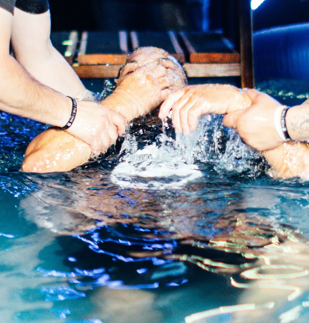 Person being lowered into the water during baptism