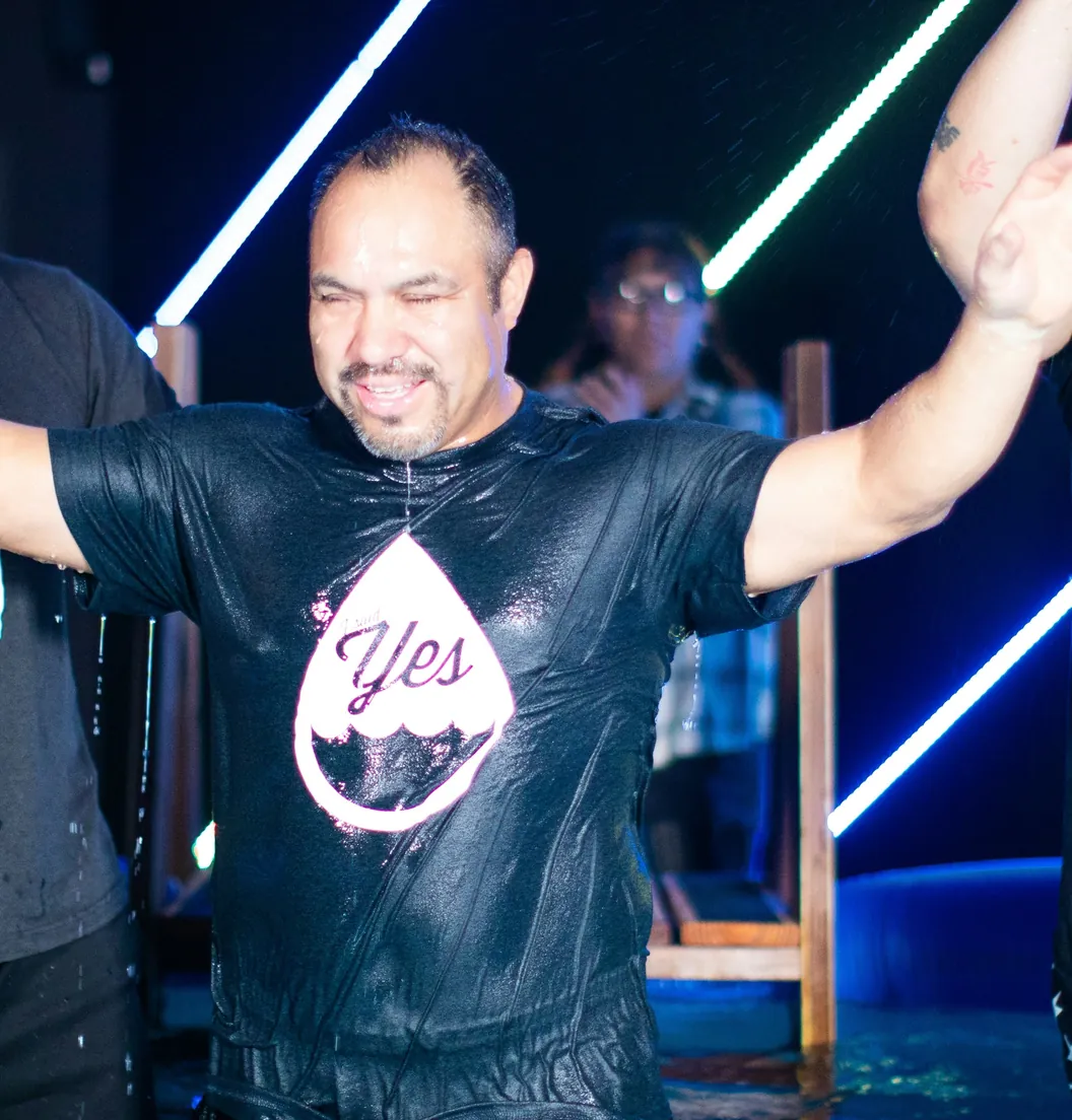 Man celebrating with his arms raised after his baptism