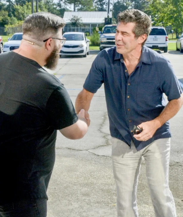 Two men shaking hands outside the church