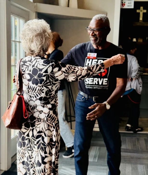Volunteer greeting a guest at the entrance