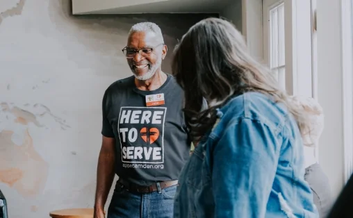 Volunteer welcoming a guest
