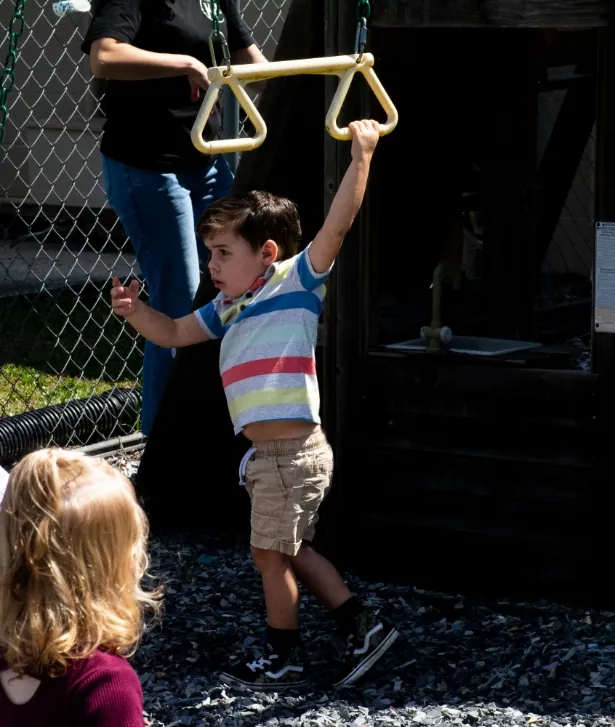 Boy hanging from the rings at the playground