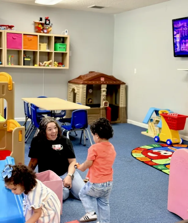 Volunteer playing with toddlers in the nursery