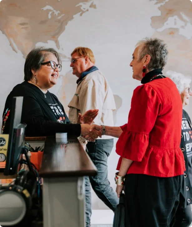 Greeters welcoming guests in front of the world map wall